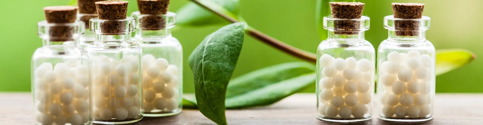 Globulis in Vintage-Flaschen. Blätter im Hintergrund.